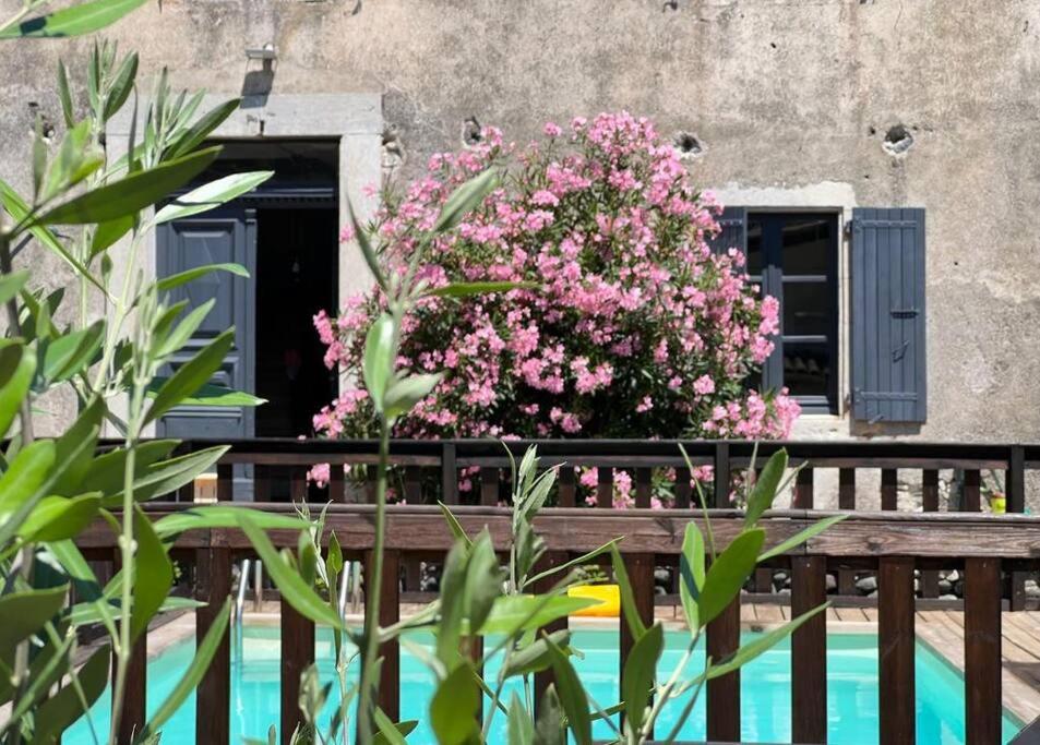 une fenêtre avec des fleurs roses sur une clôture en bois dans l'établissement Appartement dans maison Chomérac, à Chomérac