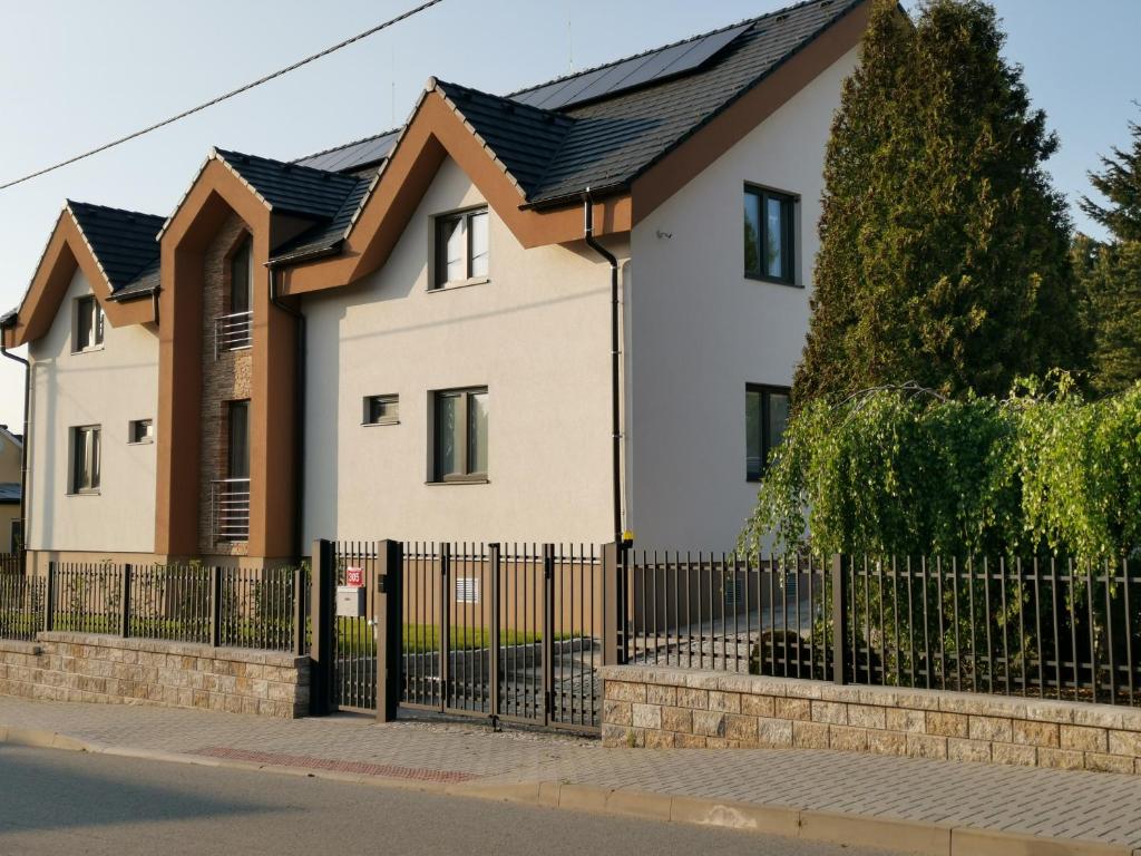 a house with a black fence at Apartmány Benedicta in Benešov