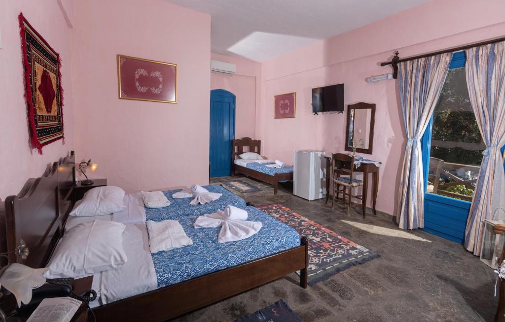 Postel nebo postele na pokoji v ubytování Arolithos Traditional Village Hotel