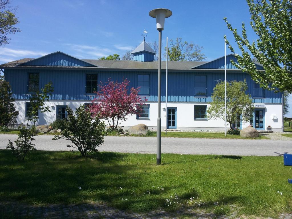 un edificio azul y blanco con un poste de luz en el césped en FeWo-Solveig, en Putgarten