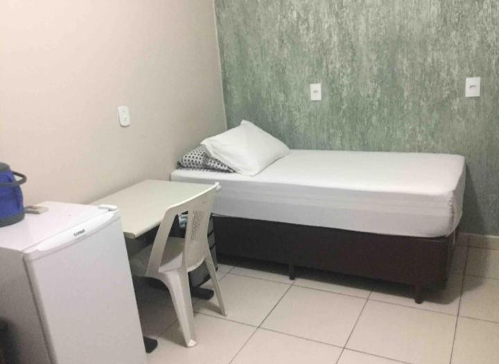a small room with a bed and a desk at Se hospede na casa da Márcia in Jundiaí