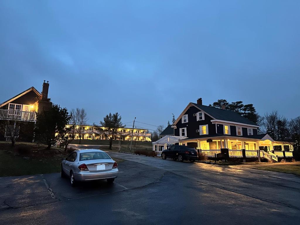 a car parked in a parking lot in front of a house at Ceilidh Country Lodge in Baddeck