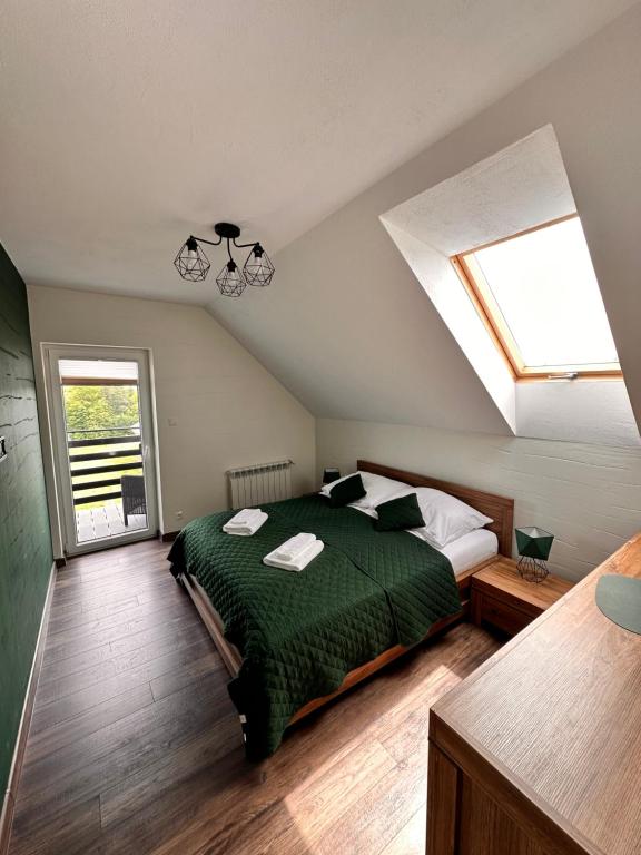 a bedroom with a bed and a skylight at Szmaragdowe Apartamenty in Polańczyk