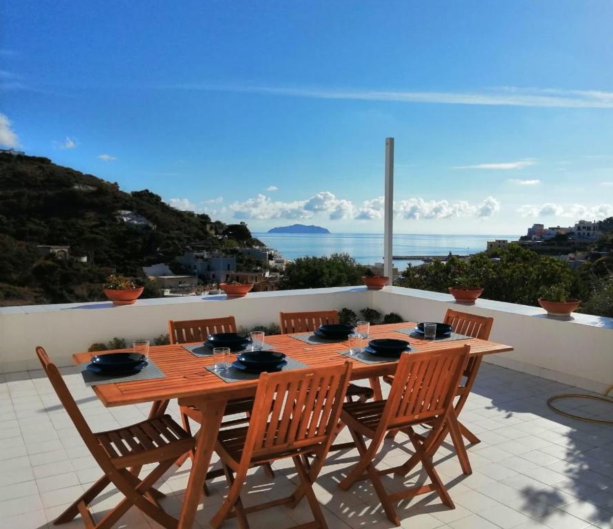 a wooden table and chairs on a patio with a view at L'Isolana Case Vacanza Villa Alessia in Ponza