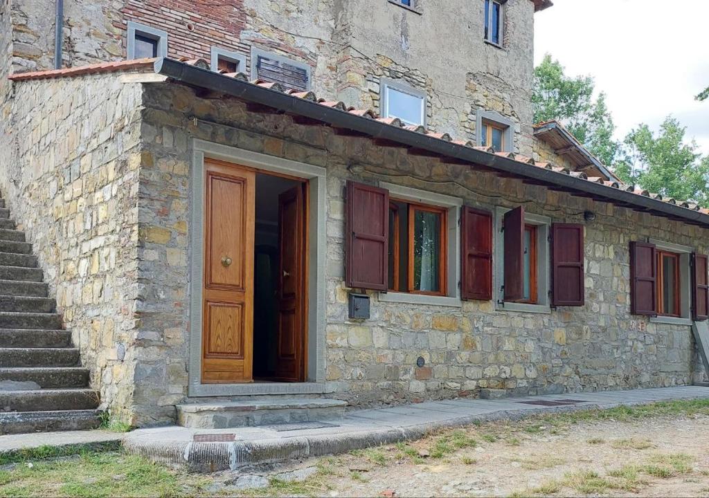 a stone building with a door and some stairs at Nido Romantico in Ortignano Raggiolo