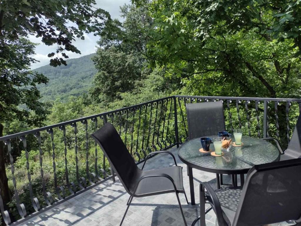 a table and chairs on a balcony with a view at Kosmajska Vila in Koraćica