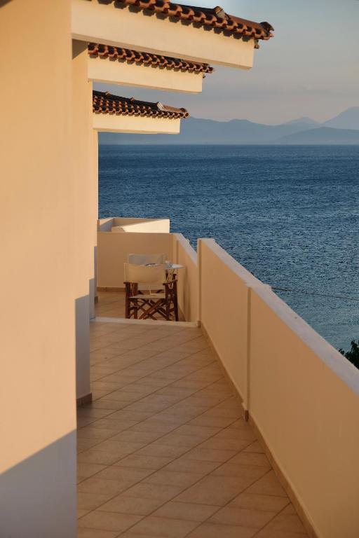 ein Balkon eines Hauses mit Blick auf das Meer in der Unterkunft Lappas Rooms in Rovies