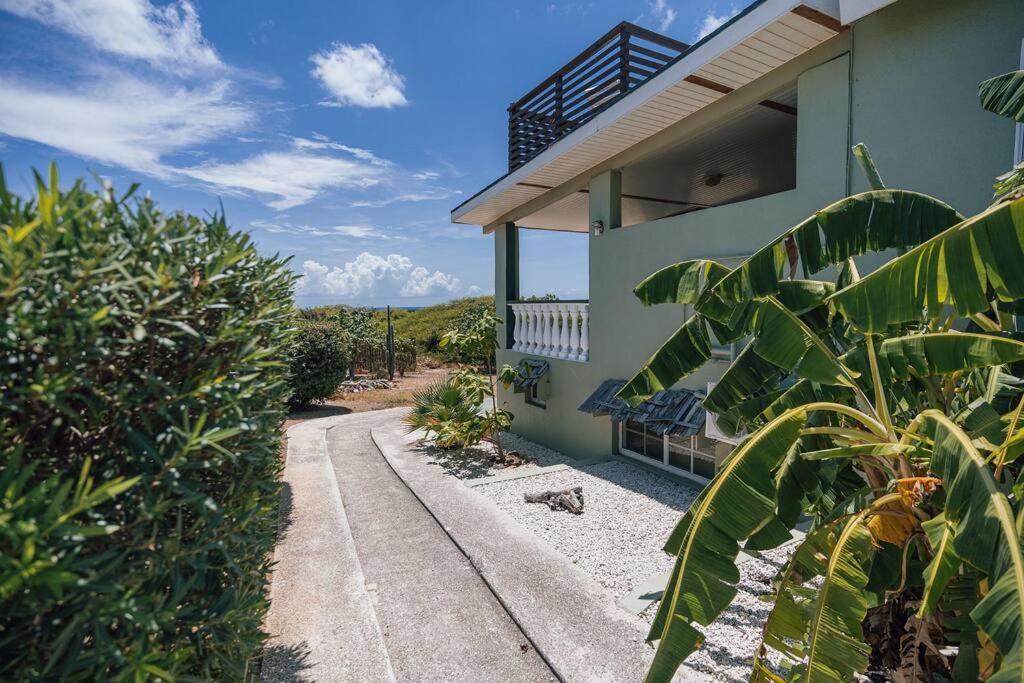una casa con una pasarela junto a un edificio en Unbounded Horizons:Serene home with Panoramic view, en Savaneta
