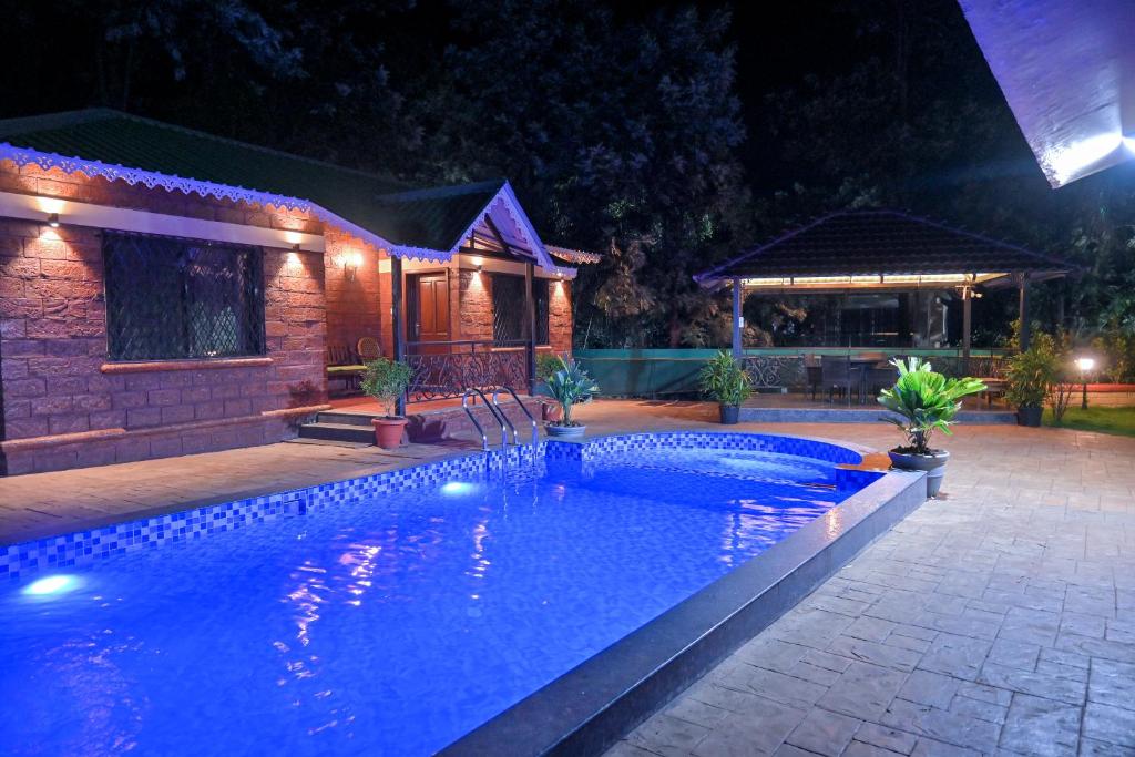 uma piscina em frente a uma casa à noite em Heaven Villa em Panchgani