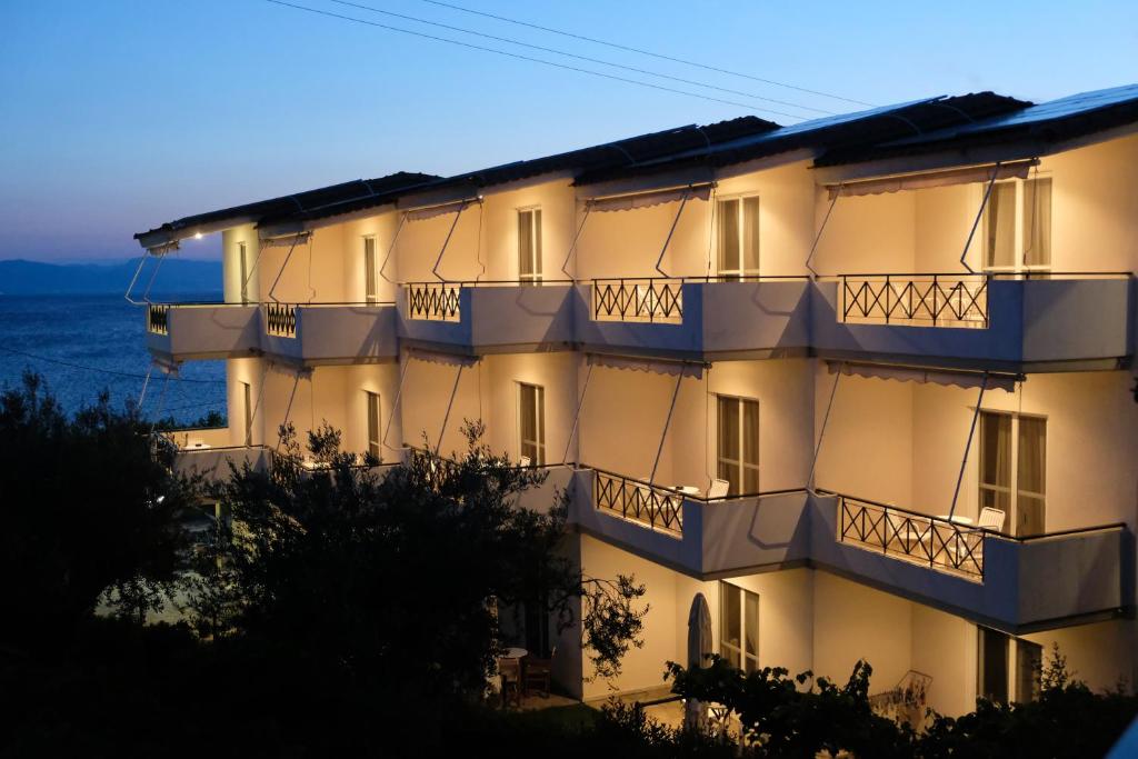 un edificio con balcones y el océano en el fondo en Lappas Rooms en Rovies