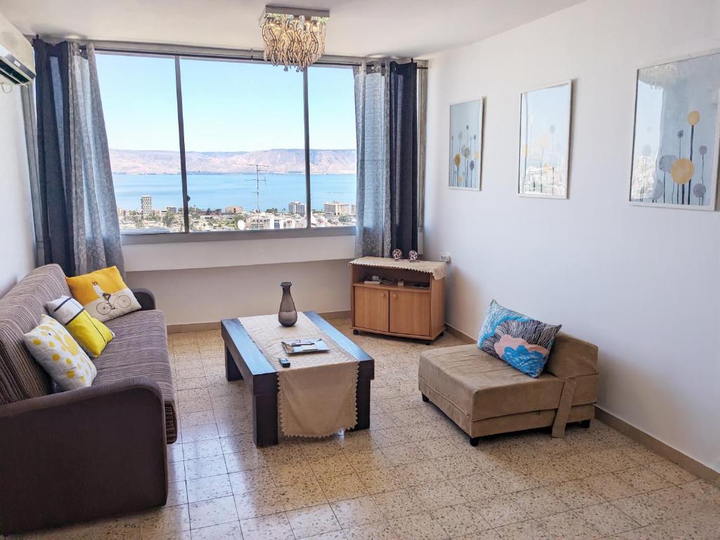 uma sala de estar com um sofá e uma mesa em 1Bdrm APT With Panoramic View of Sea and Mountains em Tiberias