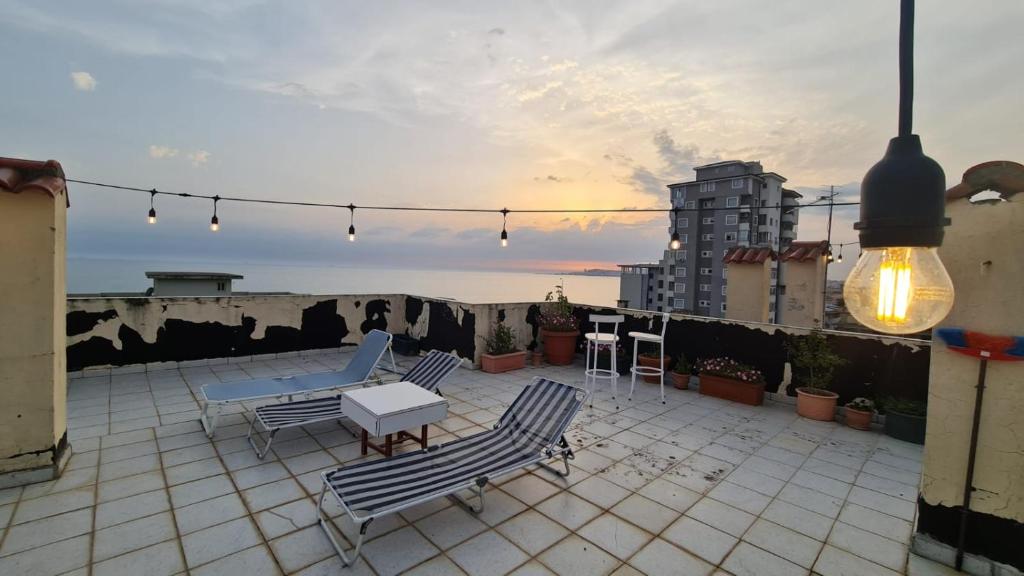 a patio with chairs and a table on a roof at Seven's Rooftop in Durrës