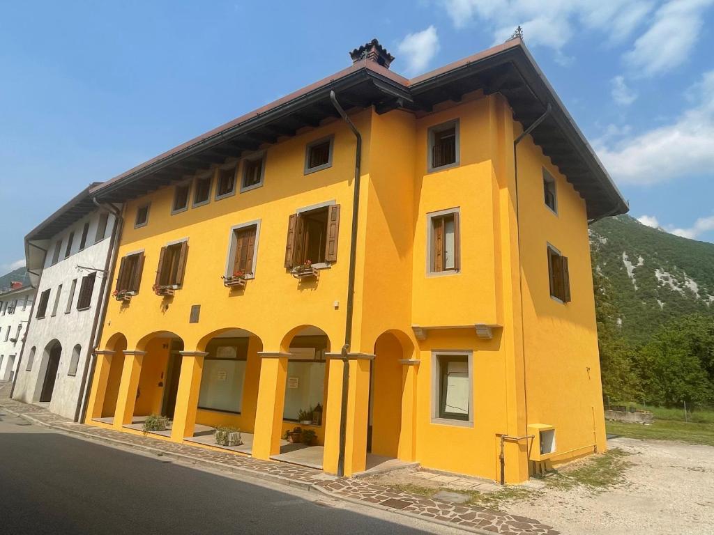 un edificio amarillo al lado de una carretera en Al Borgo Affittacamere en Venzone