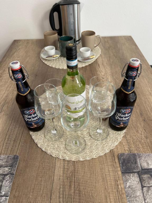 duas garrafas e dois copos numa mesa de madeira em MemmingenBuxheimKartause em Buxheim