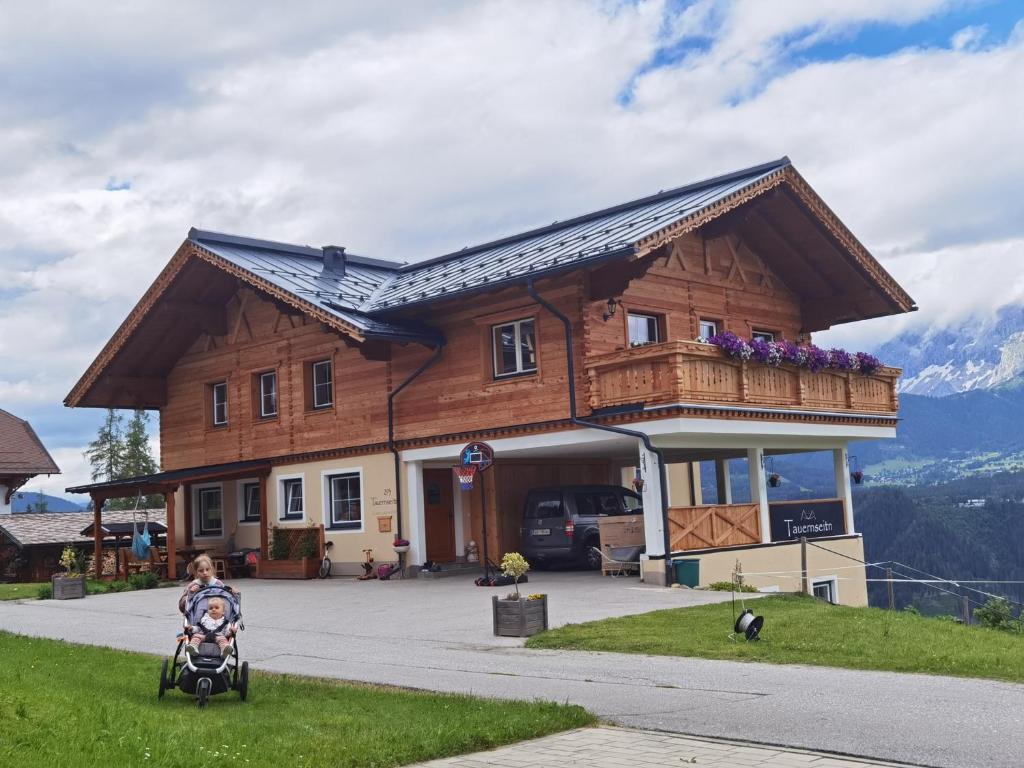 a child in a stroller in front of a building at Haus Tauernseitn in Schladming