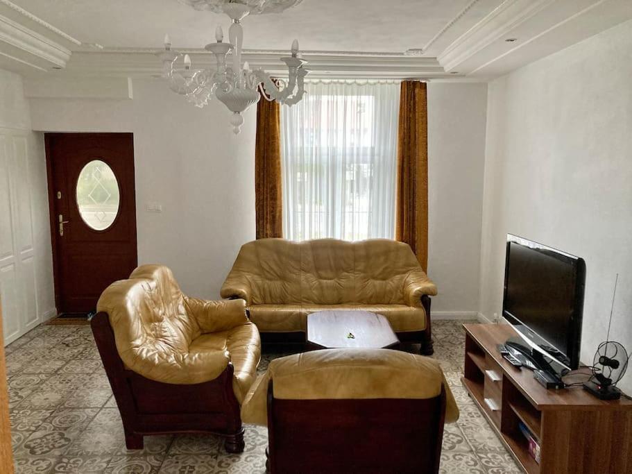 sala de estar con sofá, sillas y TV en Apartament Raszyn za grosze 