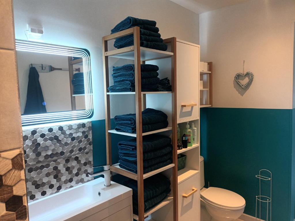 a bathroom with a rack of towels and a toilet at Au chant des mandarins 2 gites de 15 personnes et un 3ème gite à proximité de 12 in Charmes