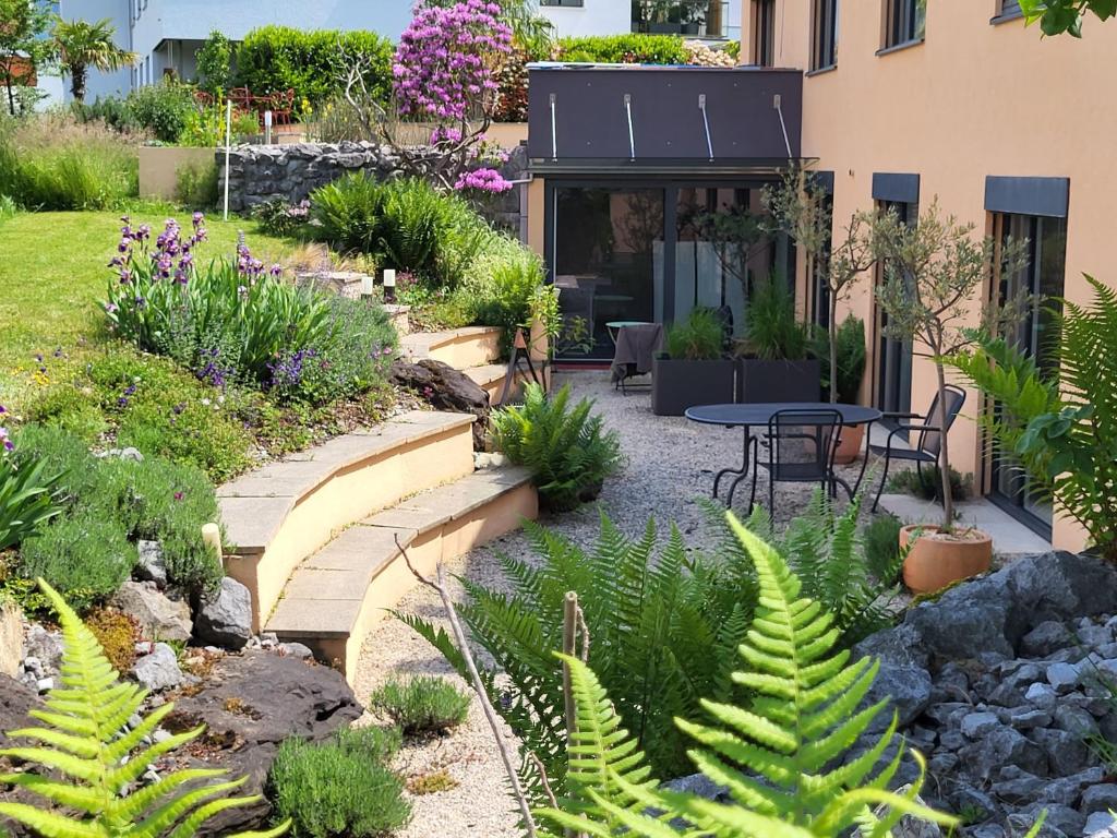 un jardin avec une terrasse, une table et des plantes dans l'établissement Oase zum SEIN, à Spiez