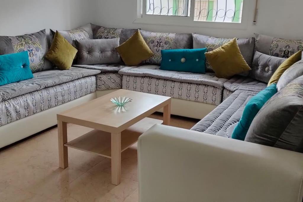 a living room with a couch and a table at joli appartement de vacances in Tétouan