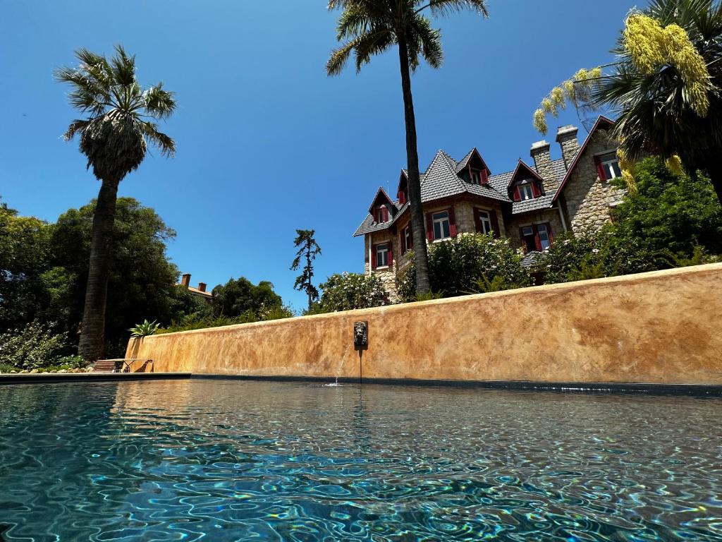 a house with palm trees in front of a swimming pool at Chalet Ficalho in Cascais
