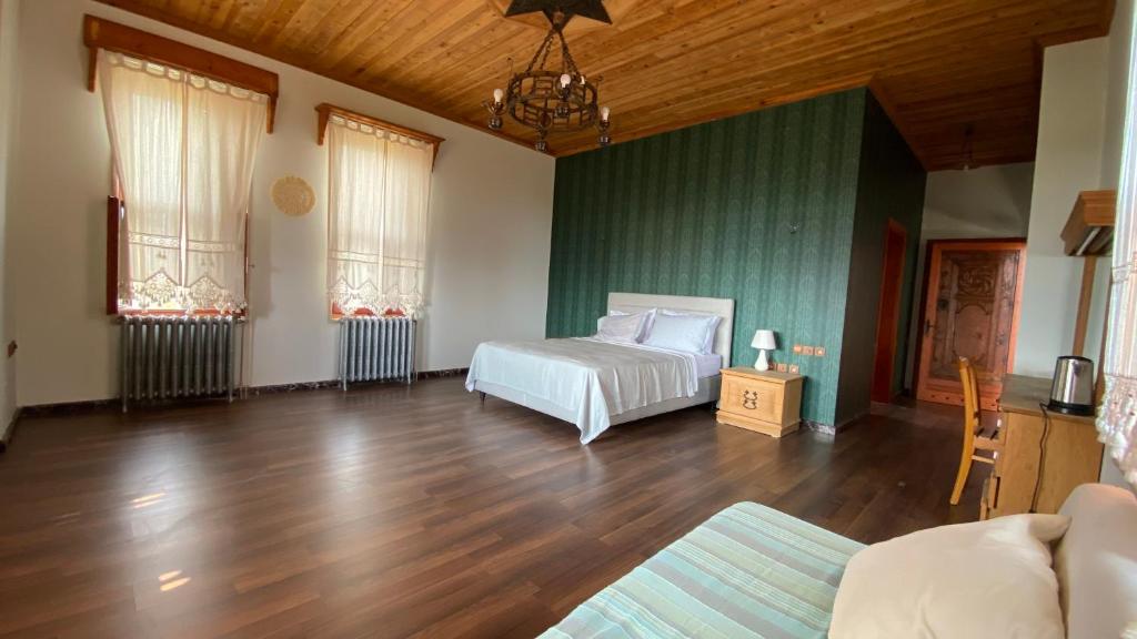 a bedroom with a white bed and a wooden floor at Stone Room in Alanya