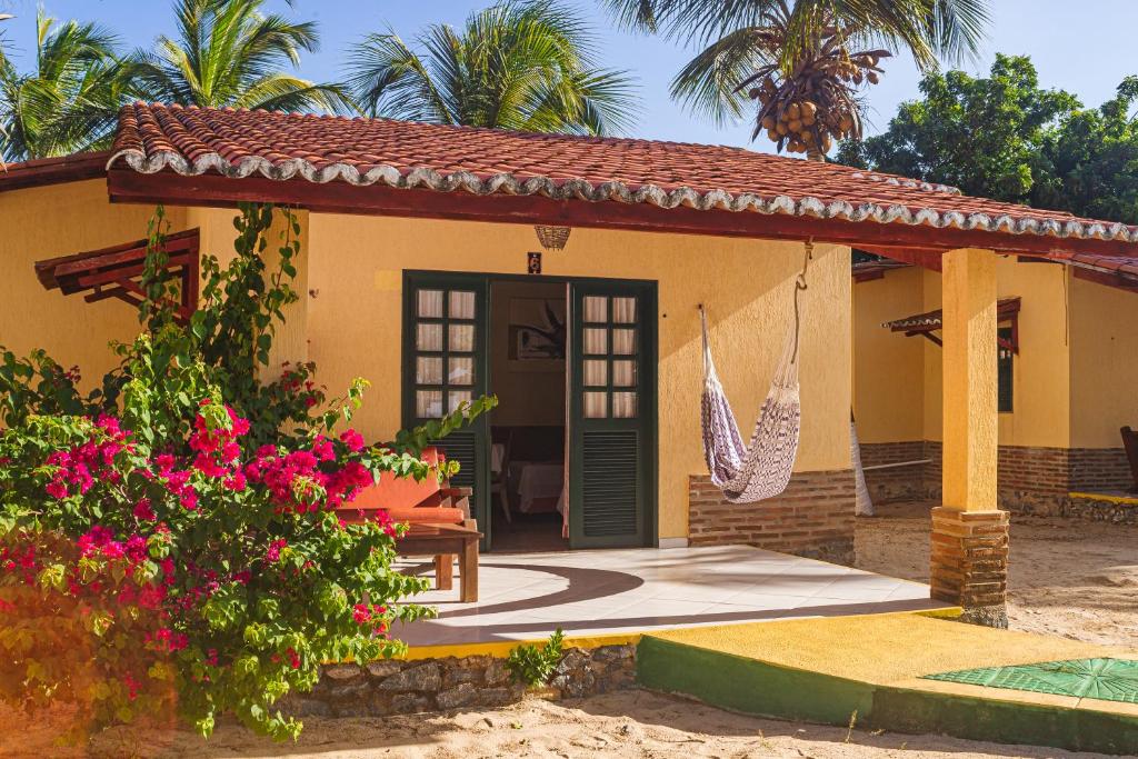 a small house with a porch and a swing at Pousada Sitio Phoenix in Prea