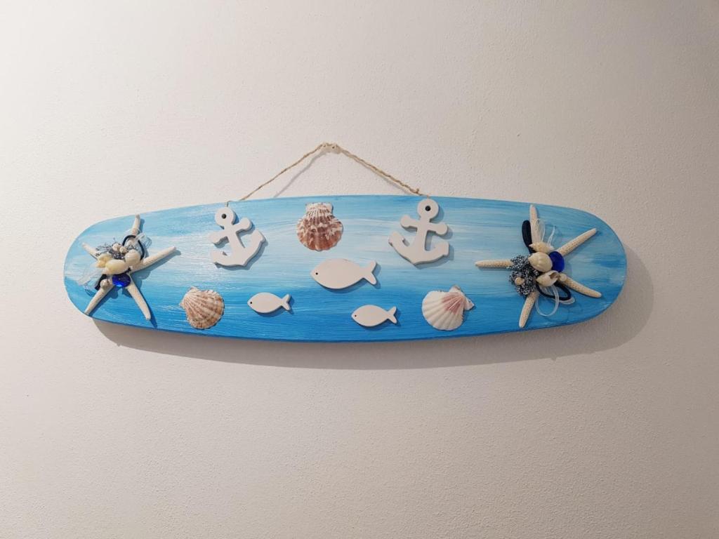 a blue surfboard hanging on a wall with toys on it at Casa Vacanze Matilde in La Spezia