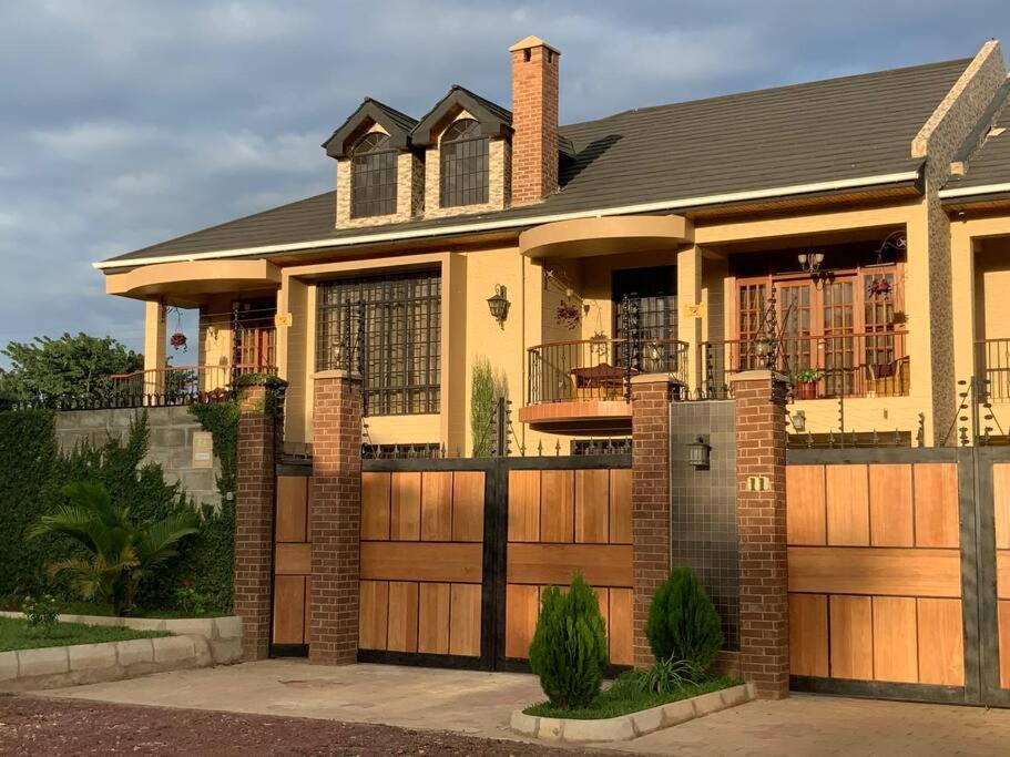 a house with a wooden gate and fence at Cornerstone Villas in Arusha