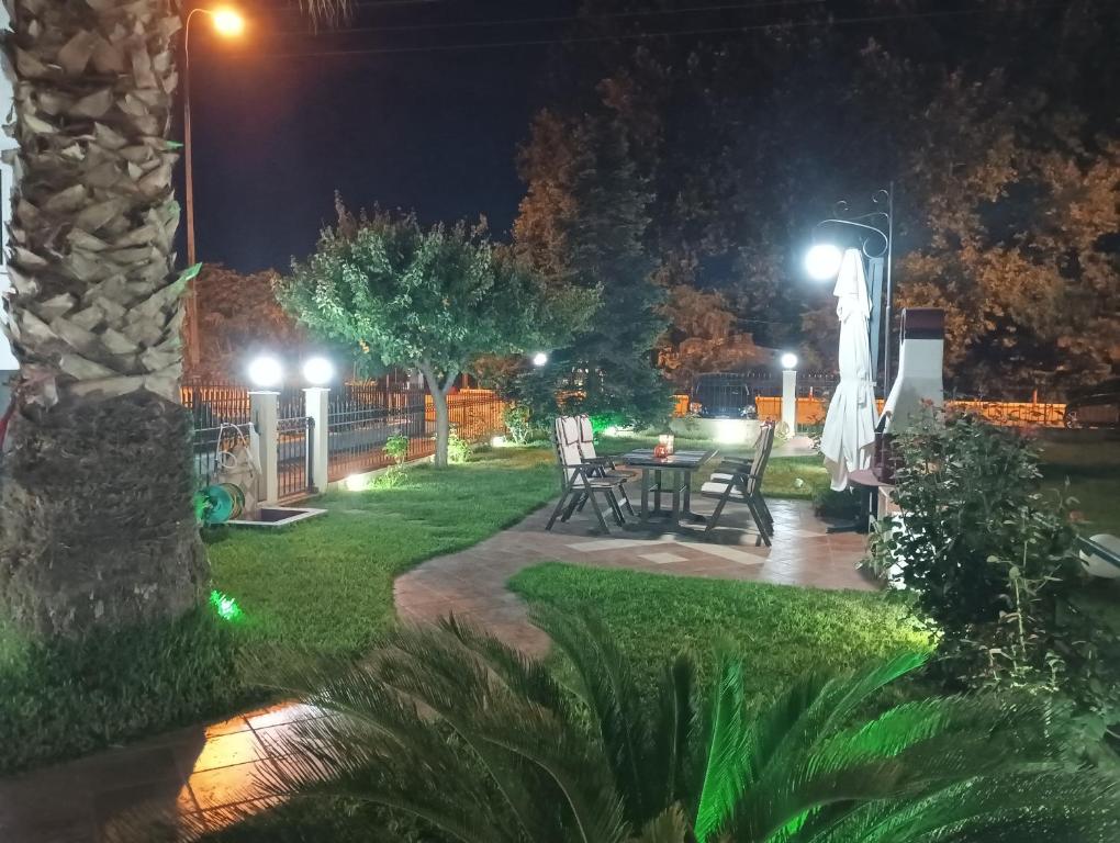einen Hinterhof in der Nacht mit einem Tisch und Stühlen in der Unterkunft by The Sea Apartment in Nea Iraklitsa