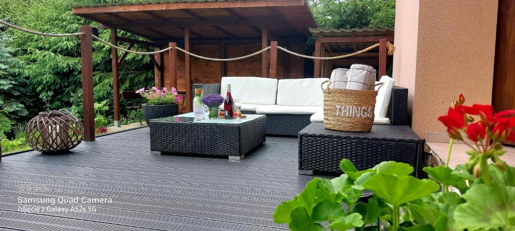 a patio with a white couch and a table at Nad Potokiem in Grąziowa