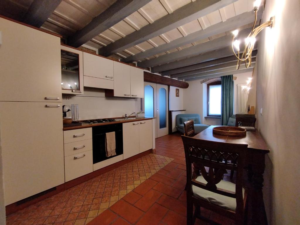 a kitchen with white cabinets and a table in a room at Rota's House in Bergamo