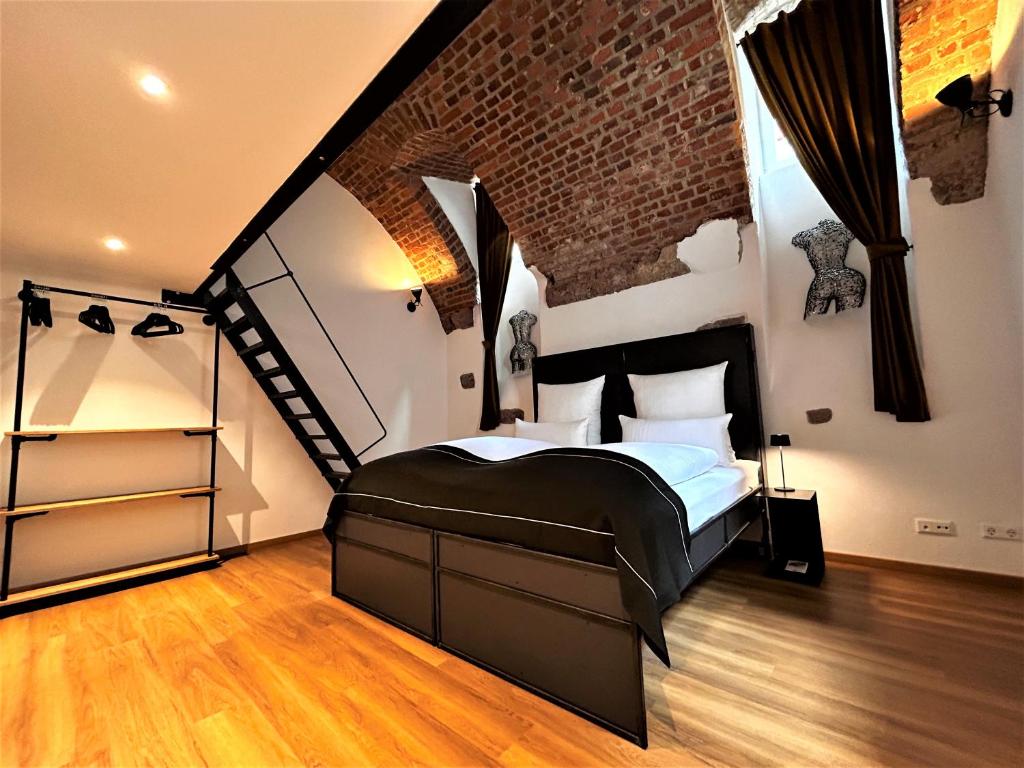 een slaapkamer met een groot bed en een bakstenen muur bij Historical Luxury Homes - Luxus Familien Suite in Freiburg im Breisgau
