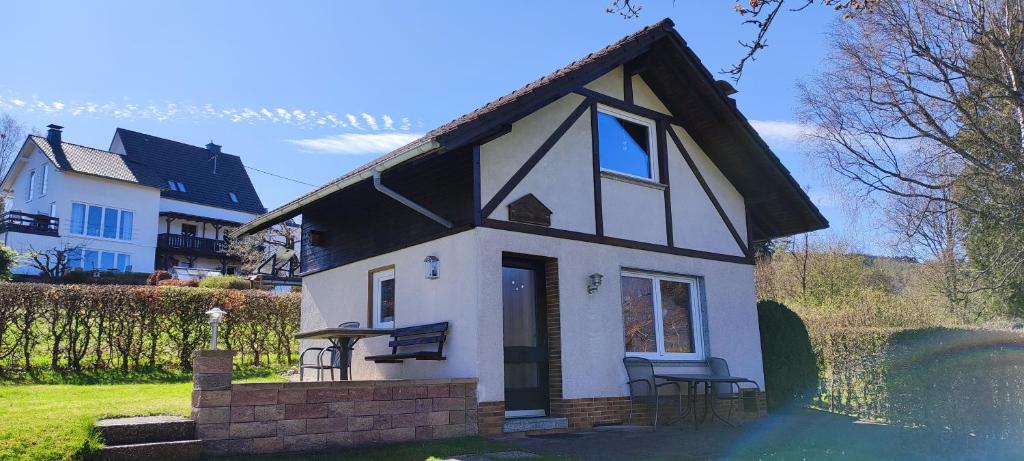 a small white house with a black roof at Ferienwohnung Gläser in Hilchenbach