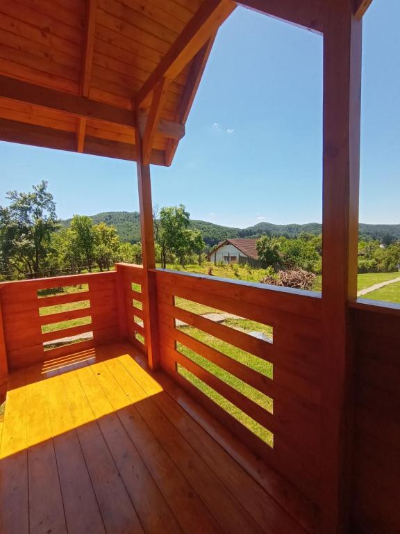 a wooden porch with a view of the mountains at Tiny H in Ocnele Mari