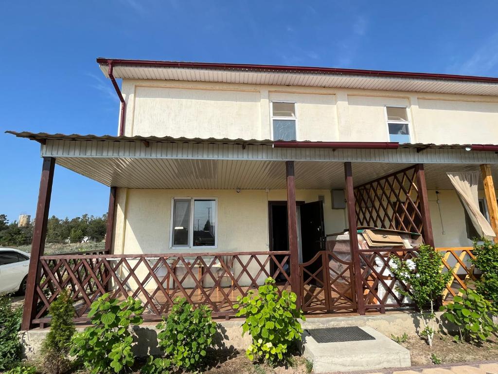 une maison avec une terrasse couverte et une clôture dans l'établissement Ailus, à Chok-Tal