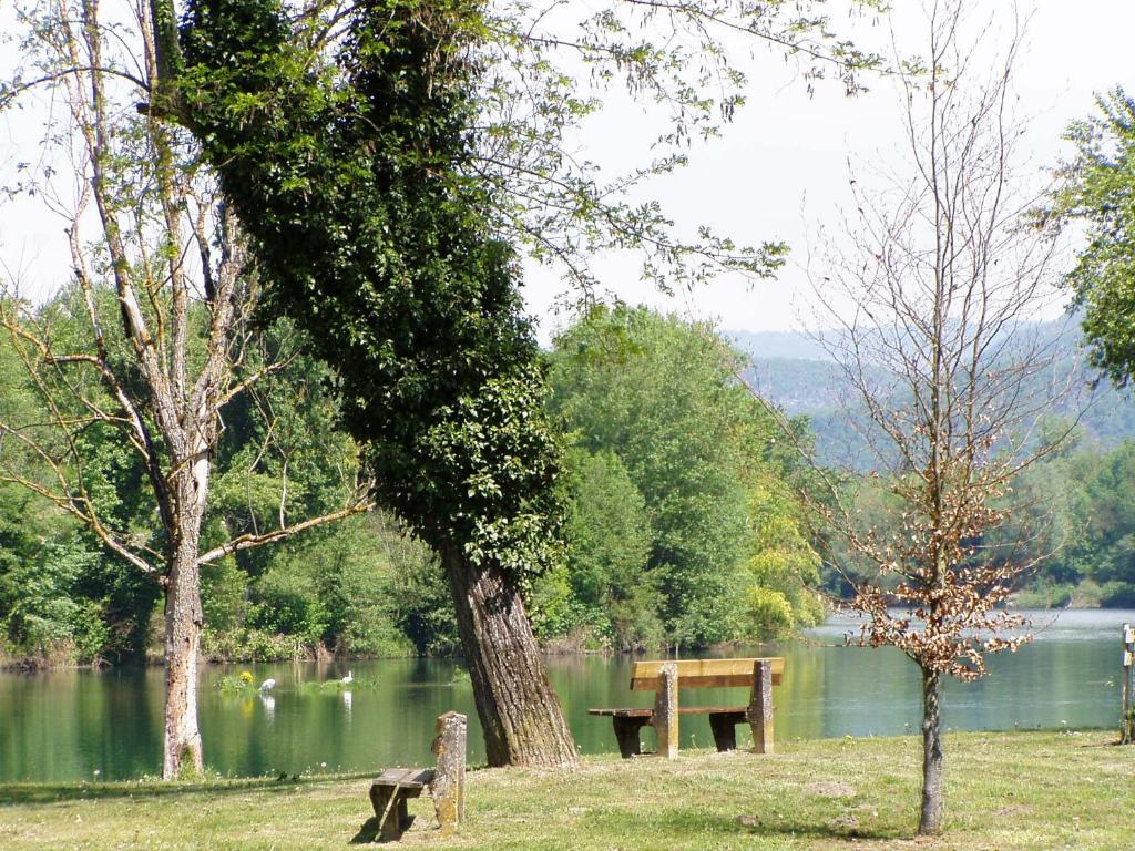 un parque con un banco junto a un lago en Au Perchoir de la Chouette, en Verneuil-en-Halatte