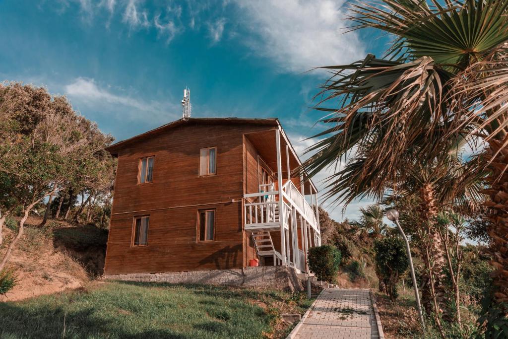 Cette maison en bois est accessible par un escalier. dans l'établissement Plazhi Gjeneralit - Small Cabins - Bungalows - Apartaments - Villas - Suite, à Kavajë