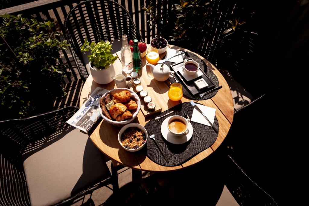 a table with breakfast food on a balcony at Suite Aux Anges in Antwerp