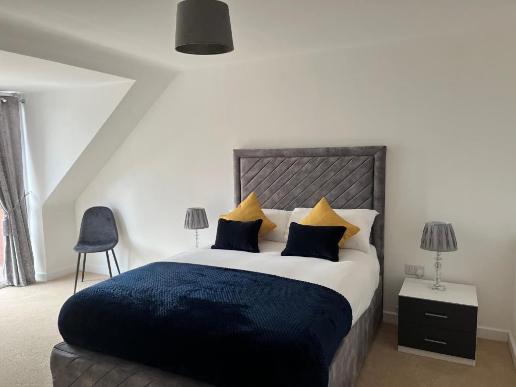 um quarto com uma cama grande com almofadas azuis e amarelas em Kingsway House - Brand New Spacious 4 Bed Home From Home em Derby
