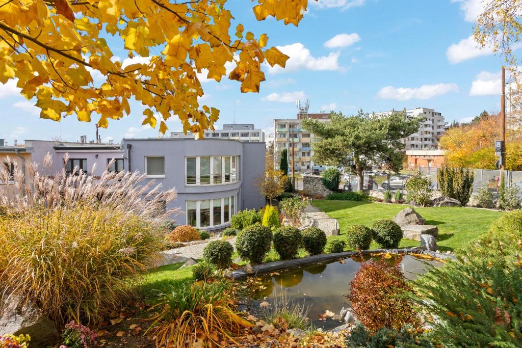 a garden with a pond in front of a building at Large private apartment with garden view, terrace and free parking in Bratislava