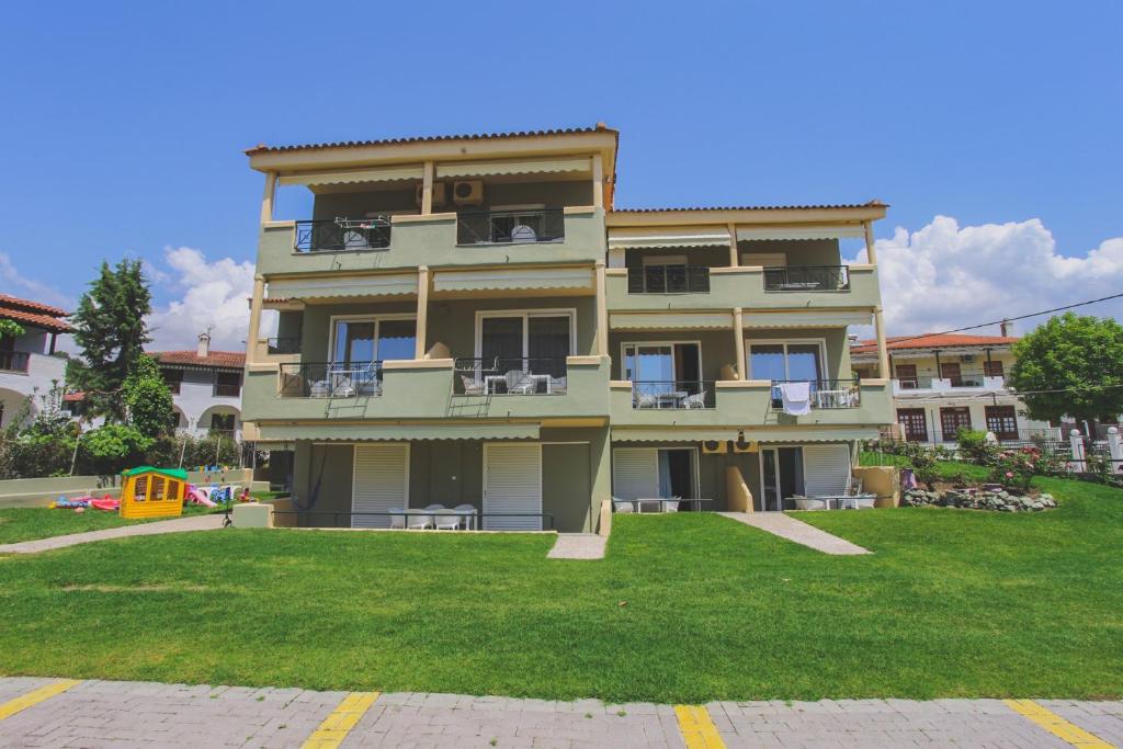 a large apartment building with a lawn in front of it at By the Sea Apartments in Siviri