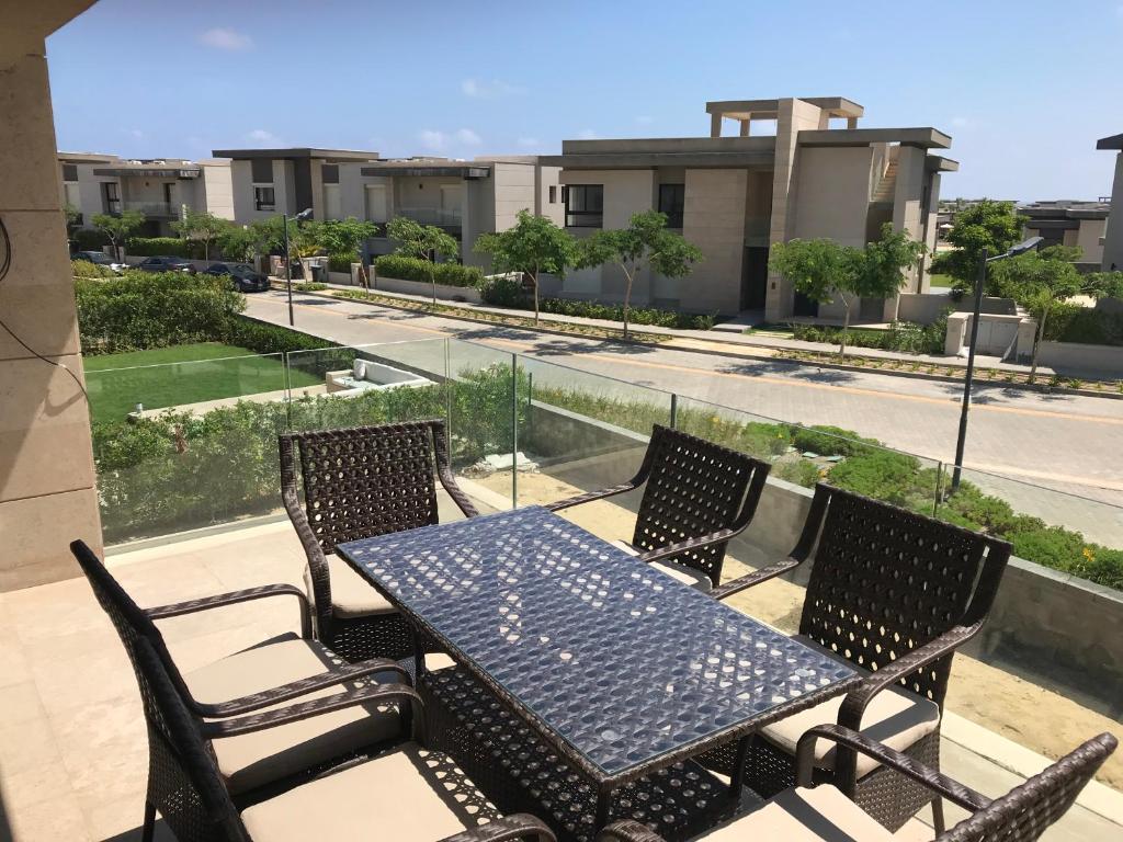 a table and chairs on a balcony with a view of a street at Swanlake north coast in Zāwiyat al ‘Awwāmah