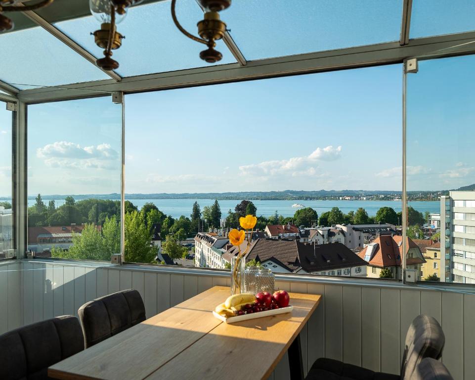einen Tisch auf einem Balkon mit Blick auf das Wasser in der Unterkunft Seeblick Bregenz in Bregenz