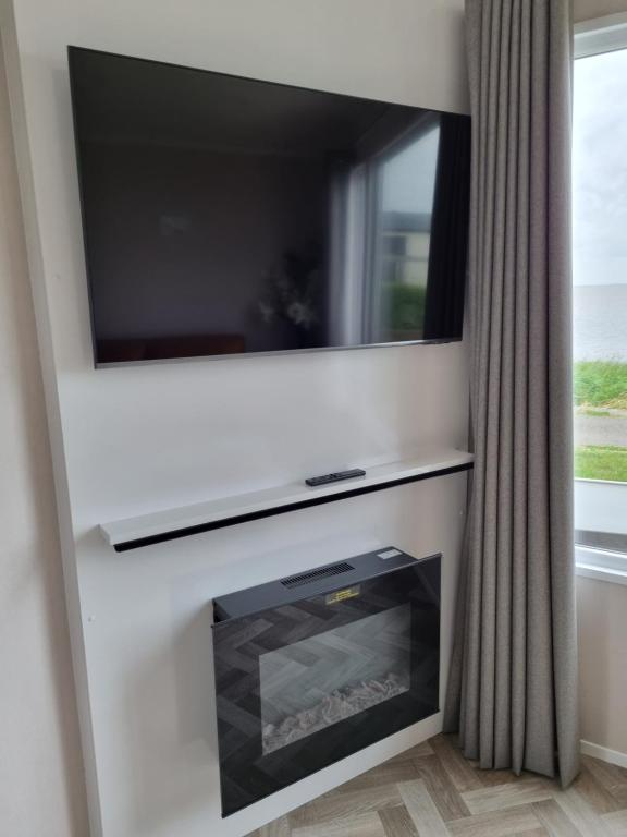 TV a/nebo společenská místnost v ubytování Camping Zeezicht Verhuur Chalet aan Zee