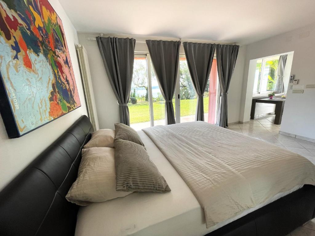 a bedroom with a bed with a couch and windows at Villa Bellavista I in Portorož