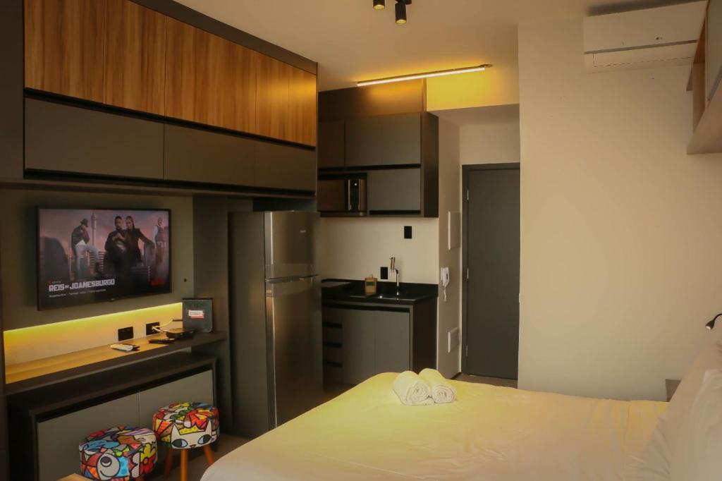 a small room with a bed and a kitchen at Belíssimo Stúdio in Sao Paulo