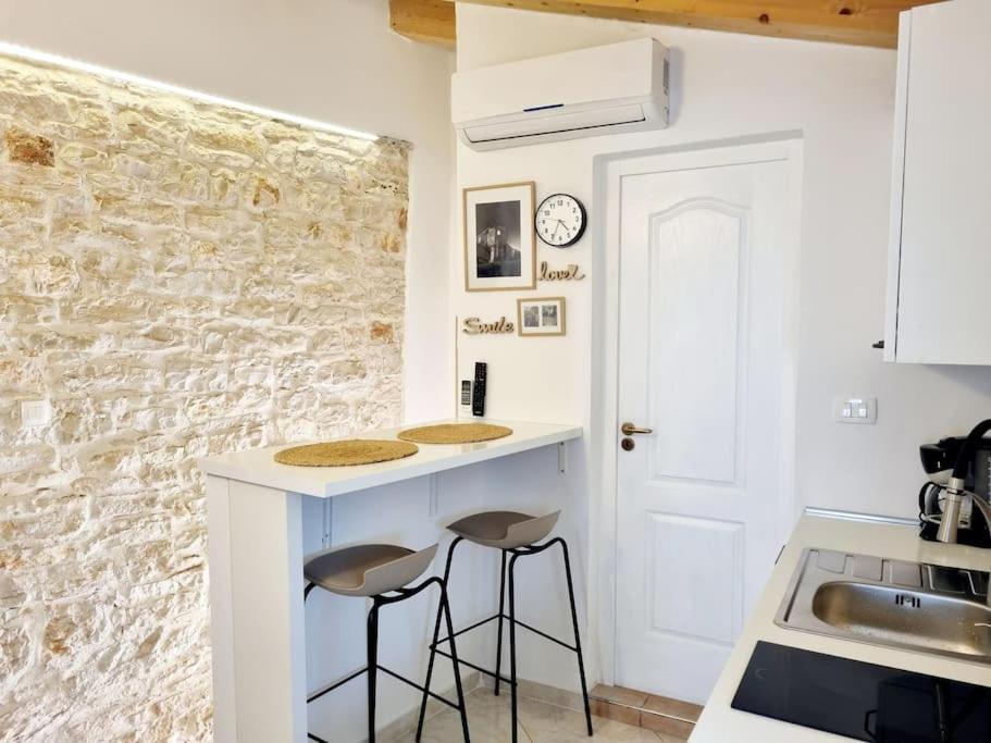 a kitchen with two stools at a counter at Stone House Mate in Rovinjsko Selo