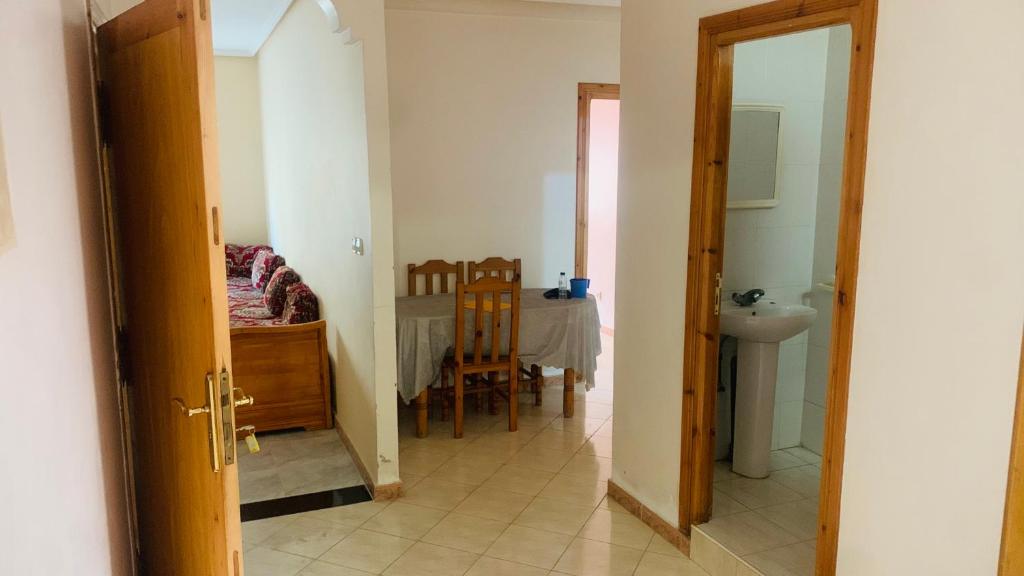 einen Flur mit einem Schlafzimmer und einem Tisch in einem Zimmer in der Unterkunft Cartier El MANAR El jadida CITY in El Jadida