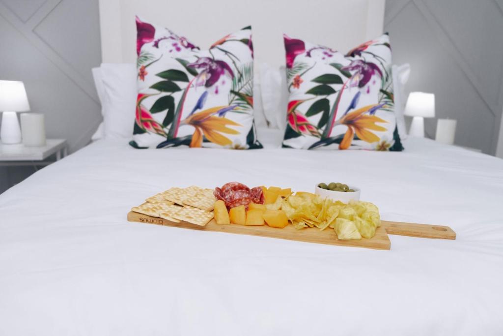 bandeja de frutas y verduras en la cama en The Lofts Luxury Suites, en Windhoek