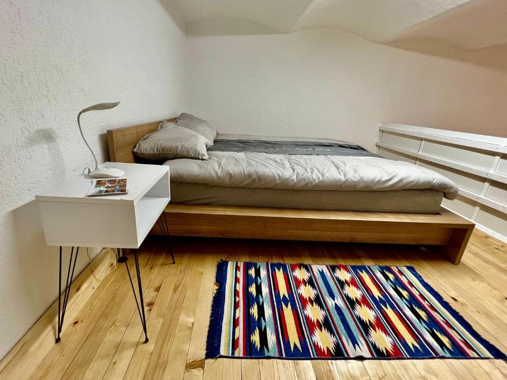 een slaapkamer met een bed, een tafel en een tapijt bij Apartman Centar in Sarajevo
